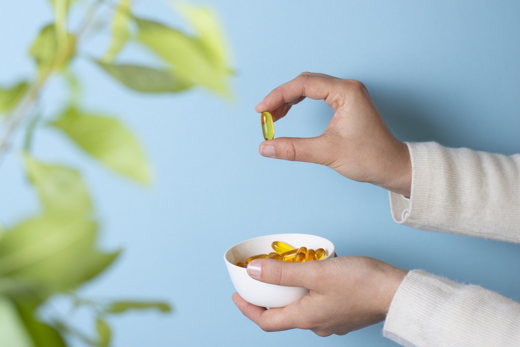mãos femininas segurando cápsulas de medicamentos naturais